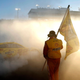 A crew member of the No. 22 Shell Pennzoil Ford waves the 2022 NASCAR Cup Series Championship flag as driver Joey Logano celebrates with a burnout after winning the 2022 NASCAR Cup Series Championship at Phoenix Raceway on November 06, 2022 in Avondale, Arizona.